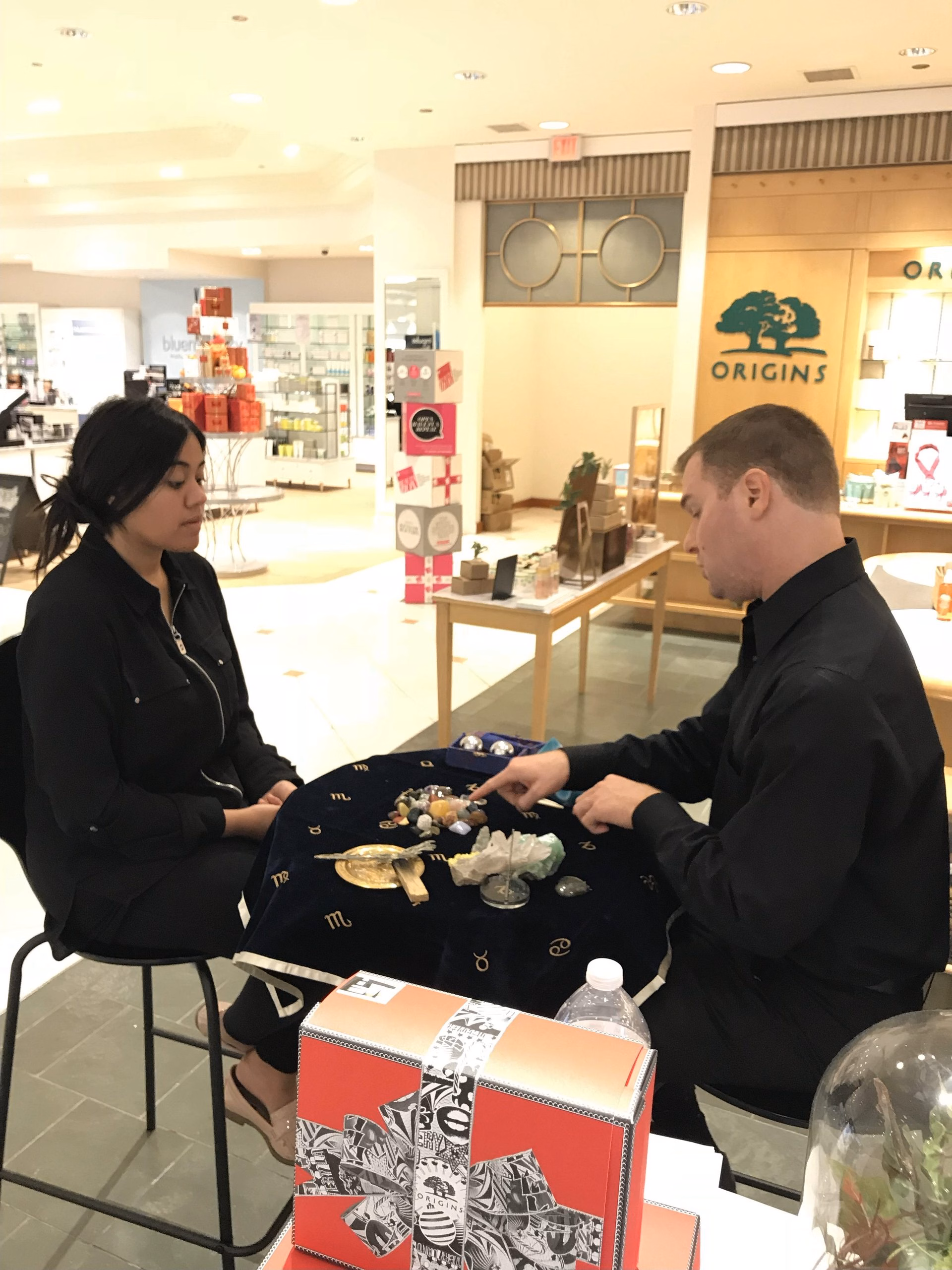 Michael performing a crystal reading at a Origins store opening event.