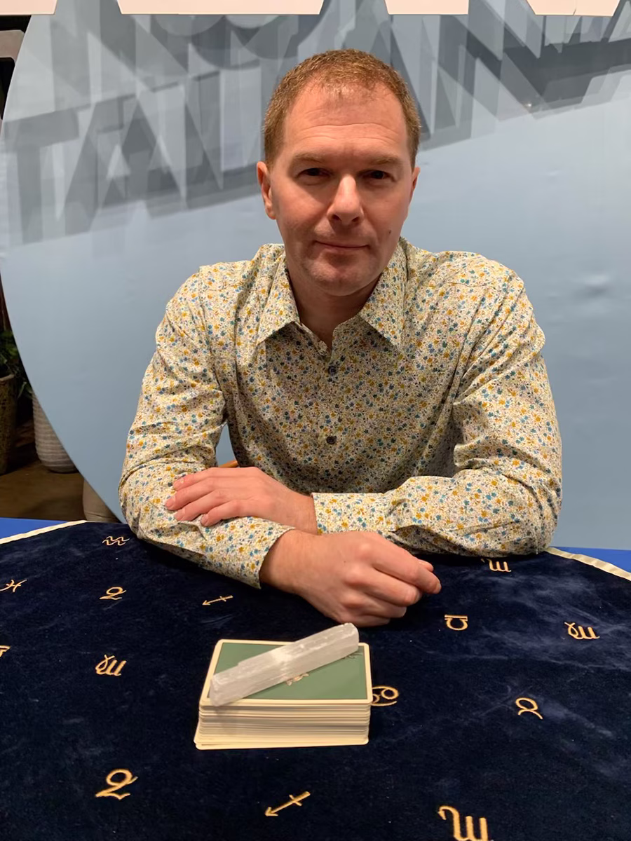 Michael Gutenplan - psychic entertainer at a table with Tarot Cards.
