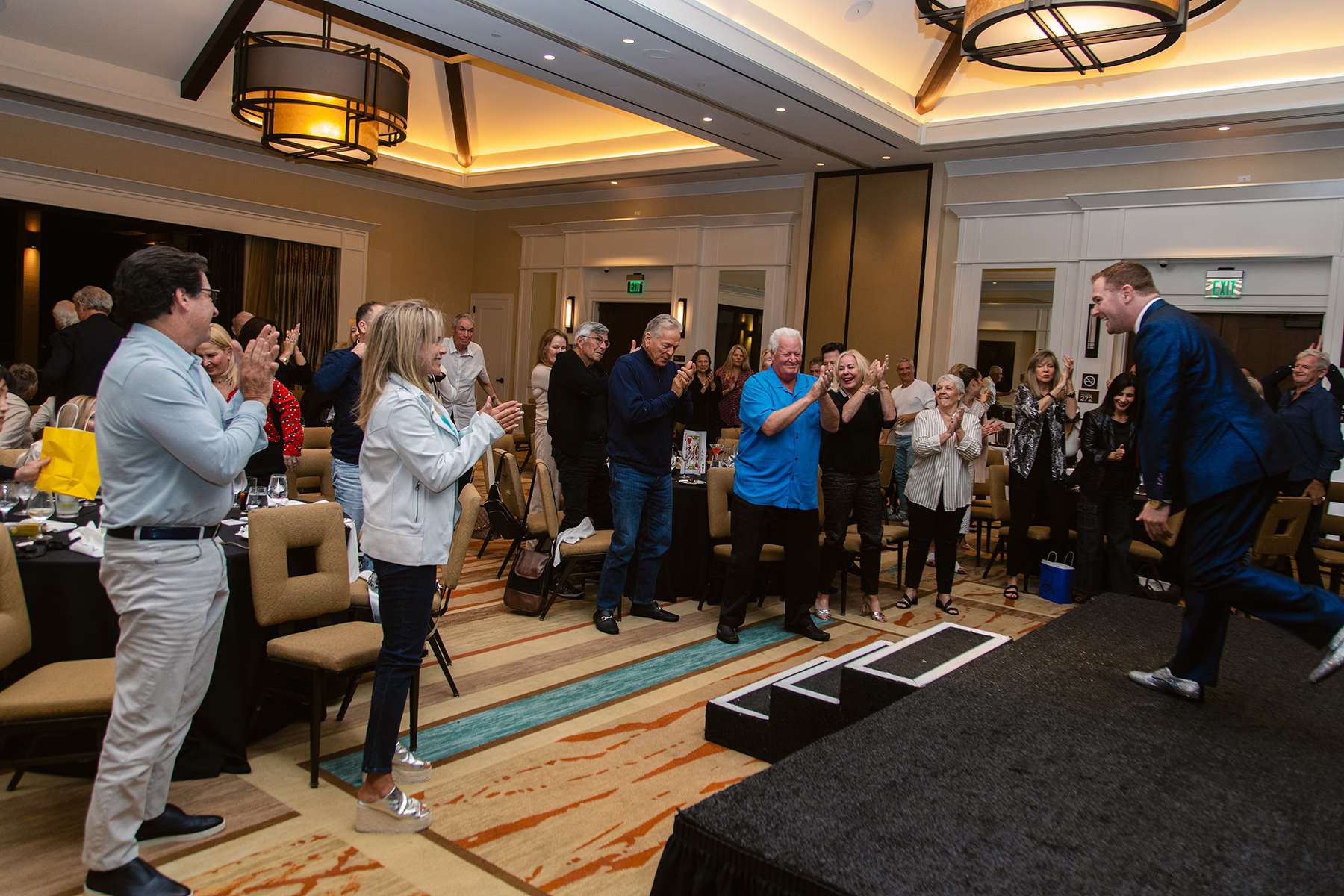 Mentalist Michael Gutenplan, on stage with a blue sparkle suit, takes a bow to a standing ovation.